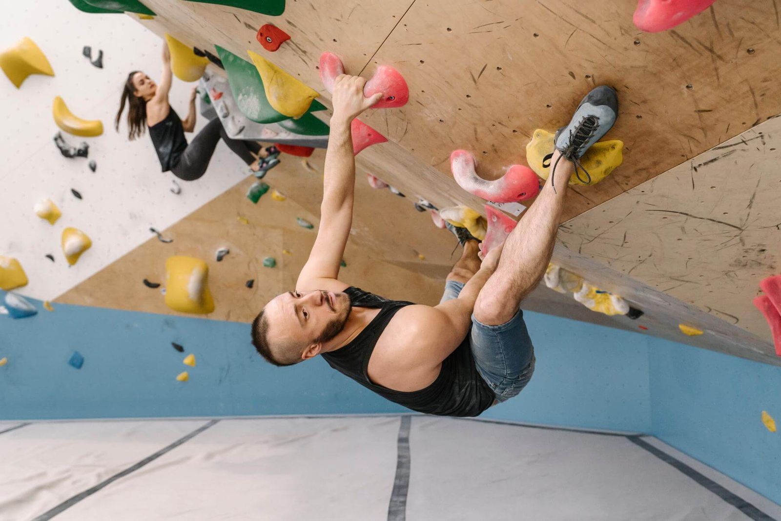 Mann bouldert dynamisch an der Überhangwand