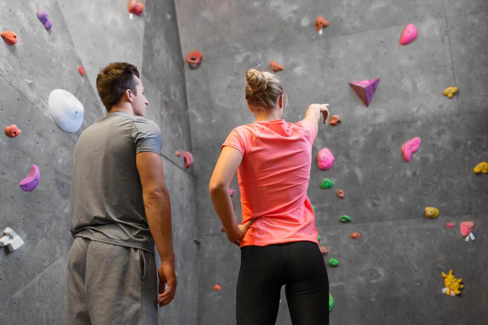 Zwei Boulderer stehen vor einer Route und besprechen gemeinsam die Bewegungen
